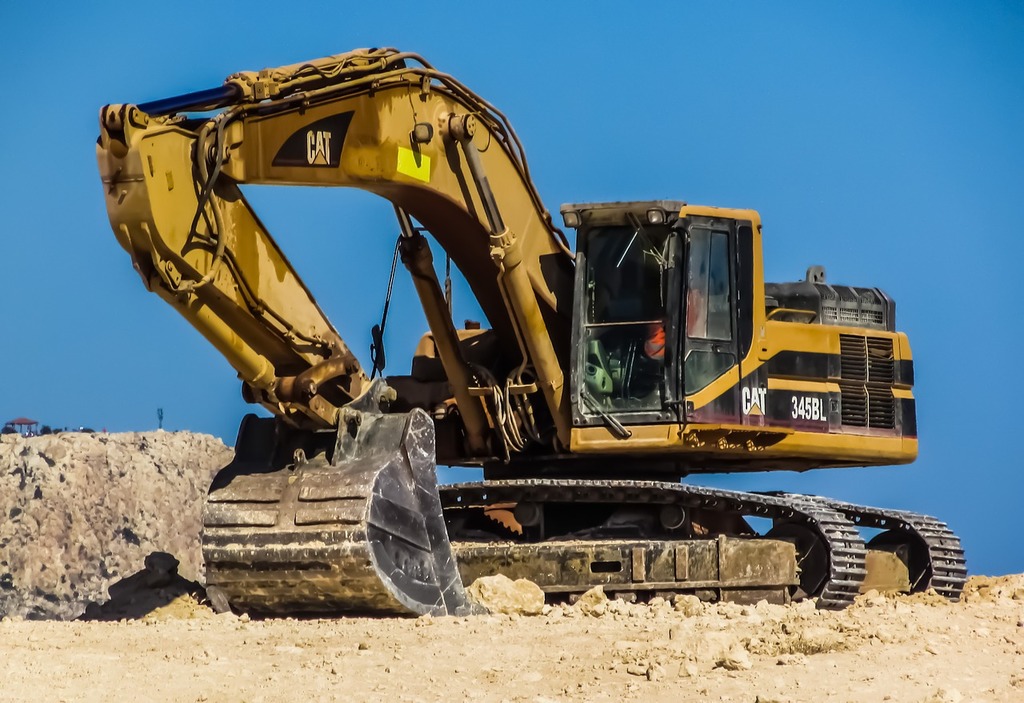 Yellow excavator heavy machinery equipment on demolition construction site